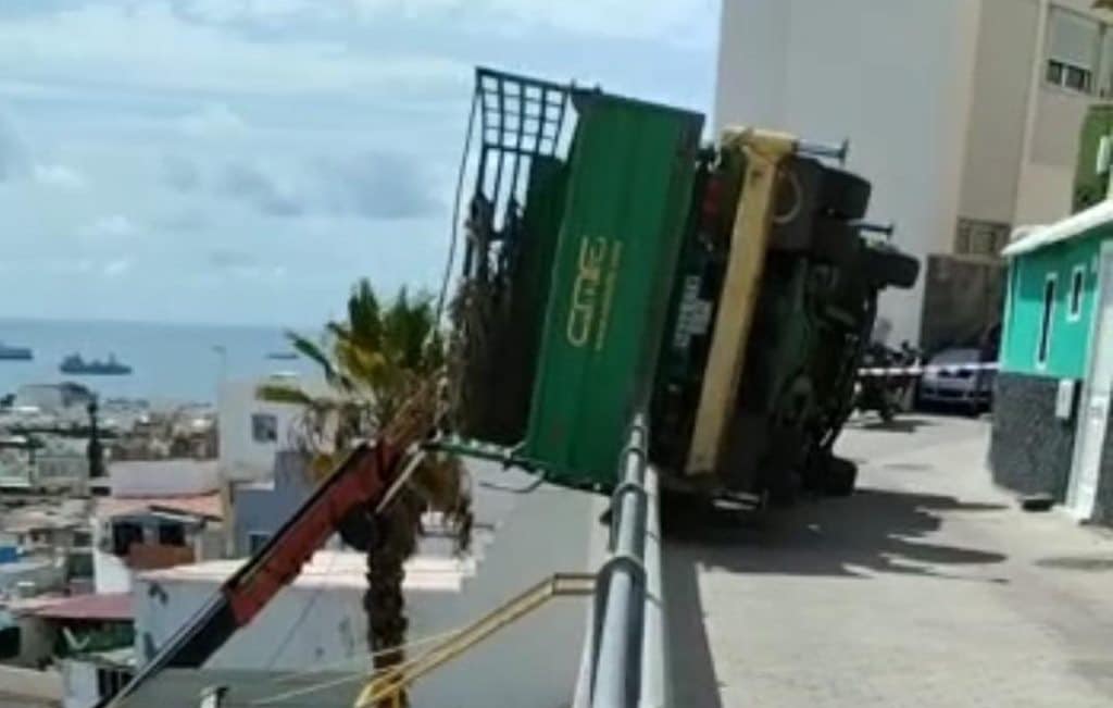 Susto en Gran Canaria: un camión queda encajado en una valla a varios metros de altura