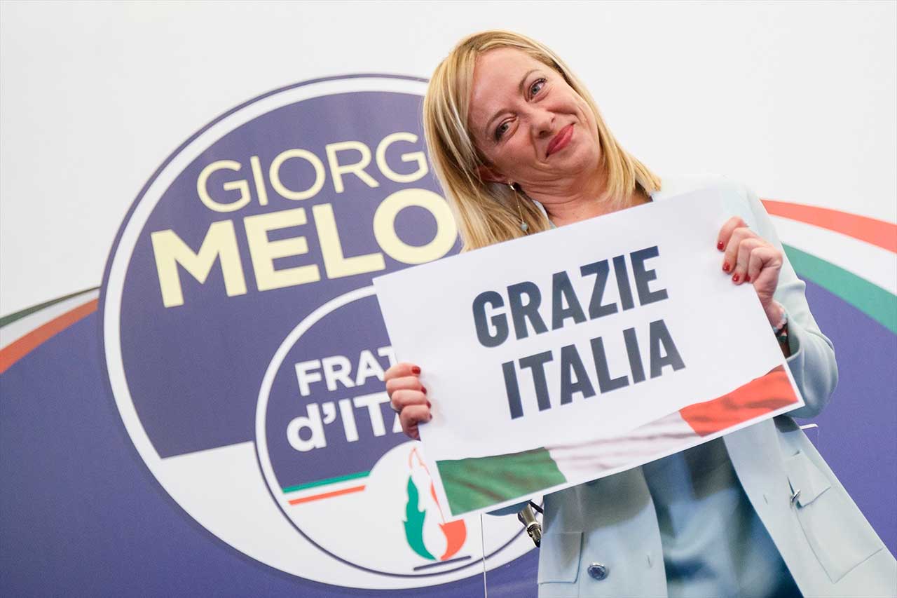 La presidenta del partido Hermanos de Italia celebra sosteniendo un cartel de agradecimiento su victoria en las elecciones italianas