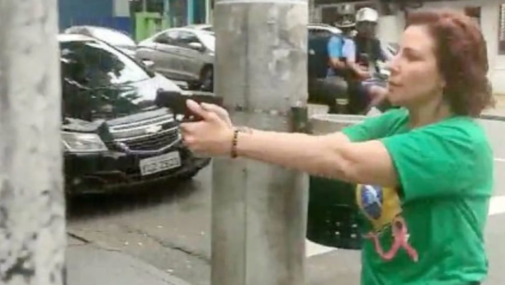 La diputada brasileña Carla Zambelli apunta con una pistola, en las calles de Sao Paulo.