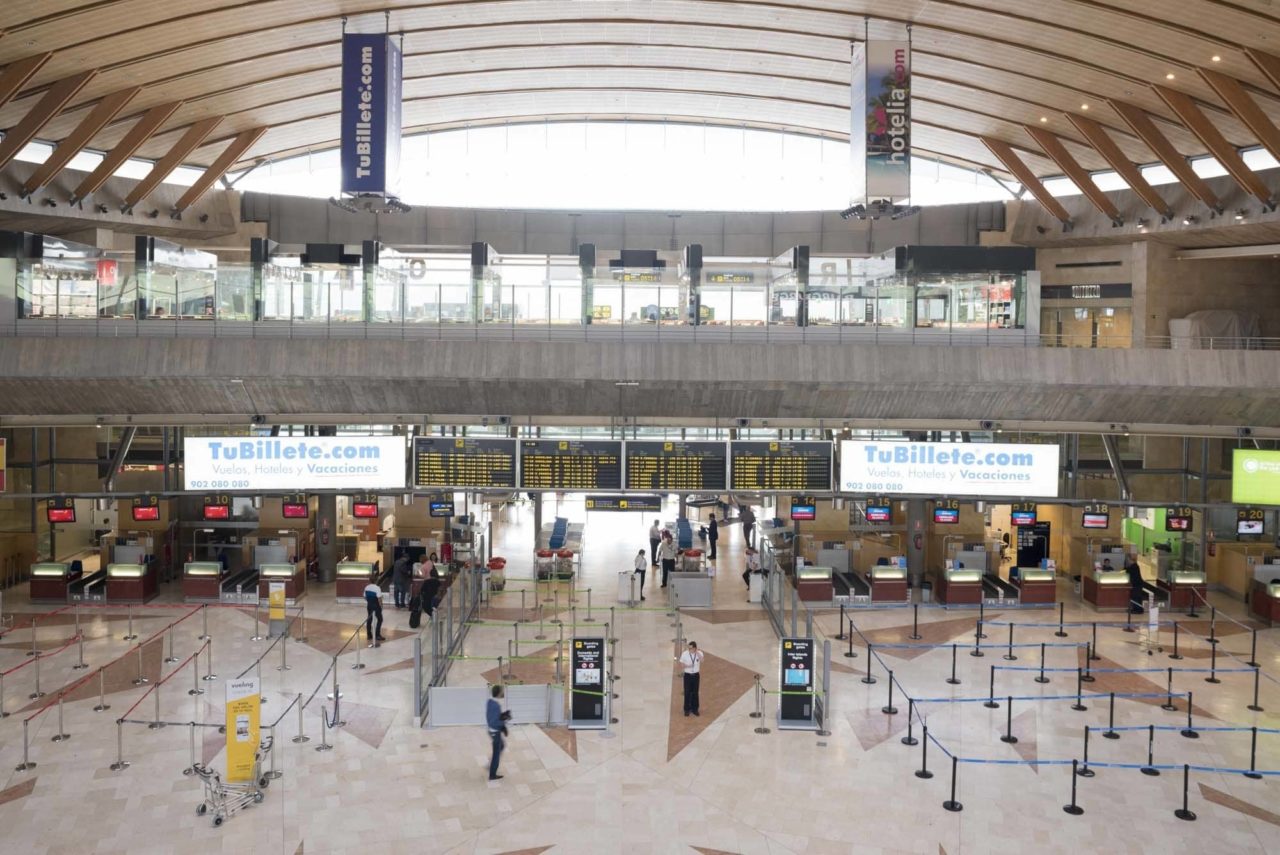 Pasajeros esperando con maletas en la zona de embarque del interior del Aeropuerto de Tenerife Norte (Los Rodeos) durante un episodio de calima