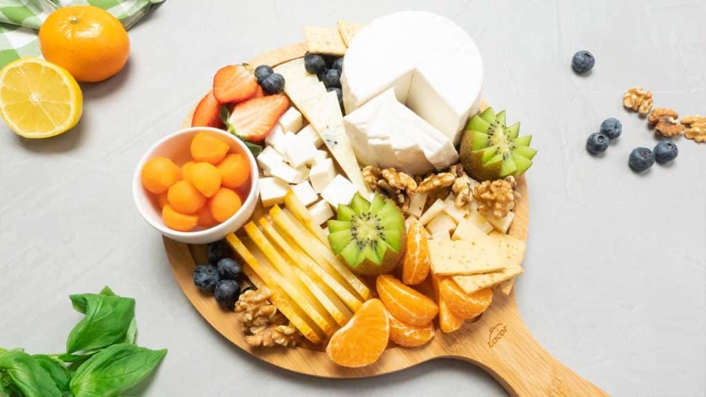 Tabla de queso y fruta en una fotografía cenital