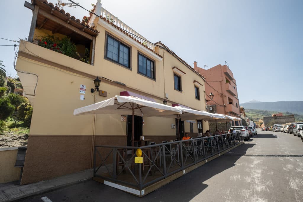 Vista del exterior del bar Chucho-Casa Emiliano, en la popular zona de la Cruz del Teide, en La Orotava; en el recuadro, el listado de empresas centenarias premiadas por el Cabildo. Fran Pallero