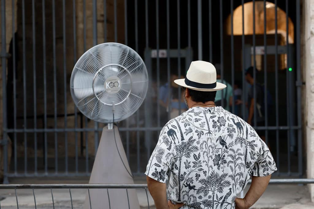Un hombre se refresca con un ventilador en el Coliseo de Roma, Italia. / Cecilia Fabiano / Lapresse Via Zum / Dpa