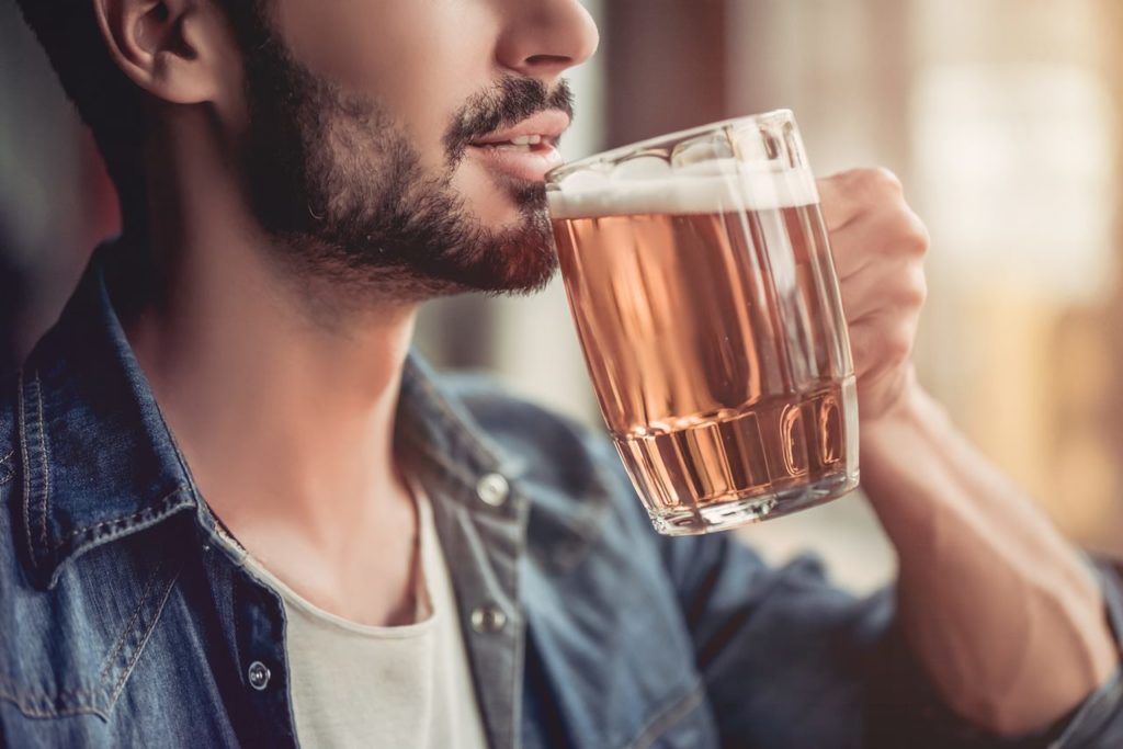Un hombre bebiendo una jarra de cerveza. Shutterstock