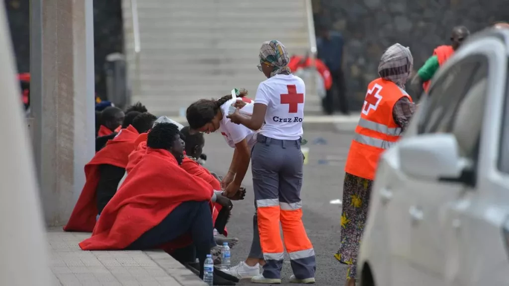 Personal de Cruz Roja atiende a un grupo de migrantes llegados ayer a La Restinga./ Efe