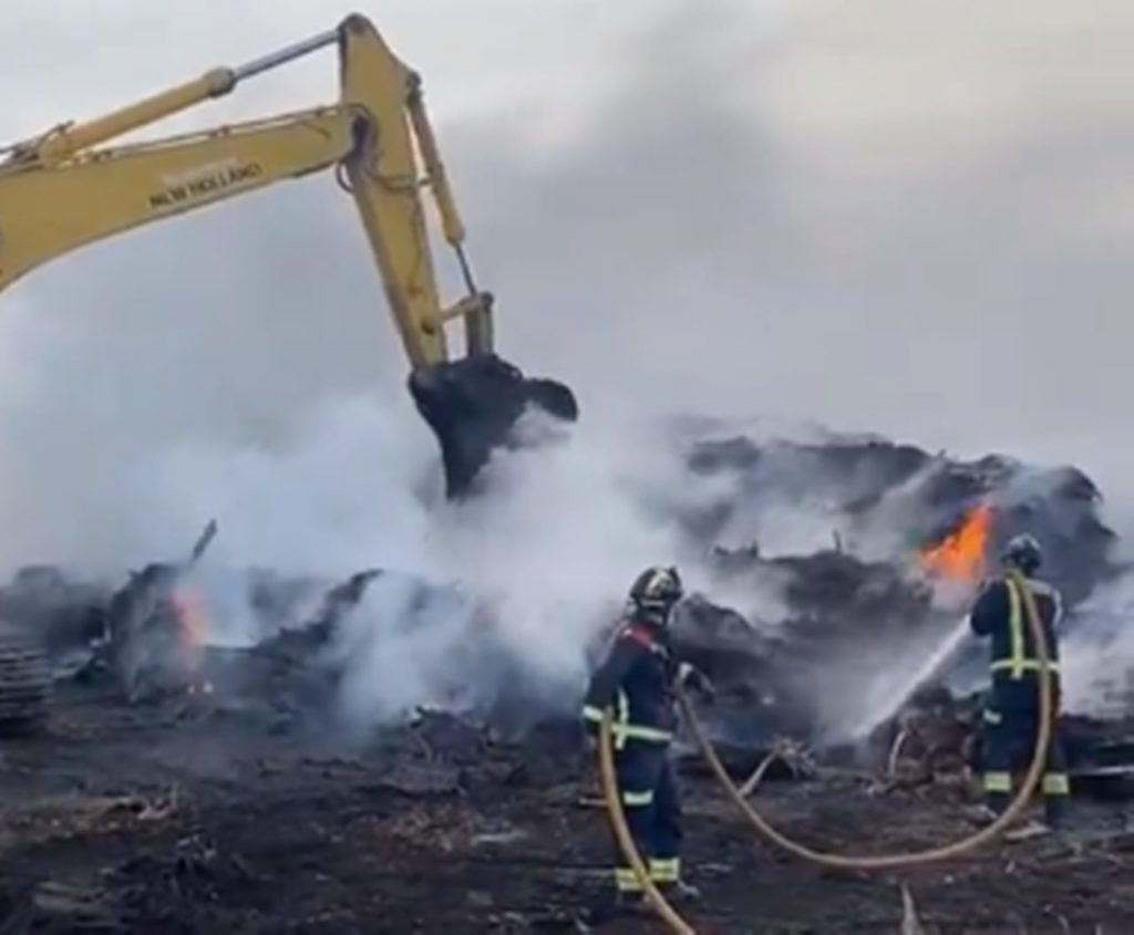 Helicópteros y maquinaria pesada refrescan el incendio en la planta de compostaje de Arona