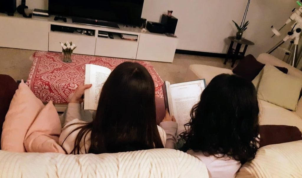 Mirella y Diana leen en el salón de su casa, en Santa Cruz de Tenerife