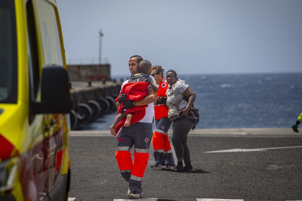 Un miembro de Salvamento Marítimo coge en brazos a un bebé migrante a su llegada a Canarias. EP