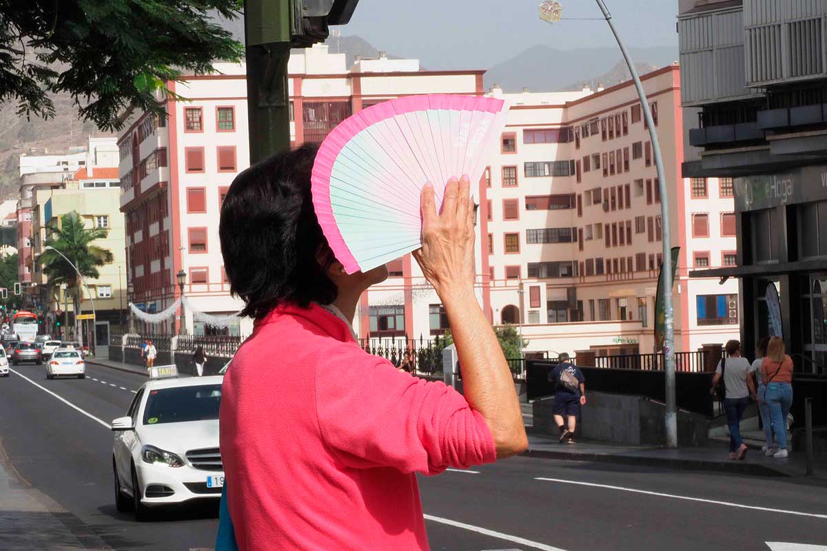 Mujer protegiéndose el rostro del calor y la calima en Canarias durante la prealerta meteorológica