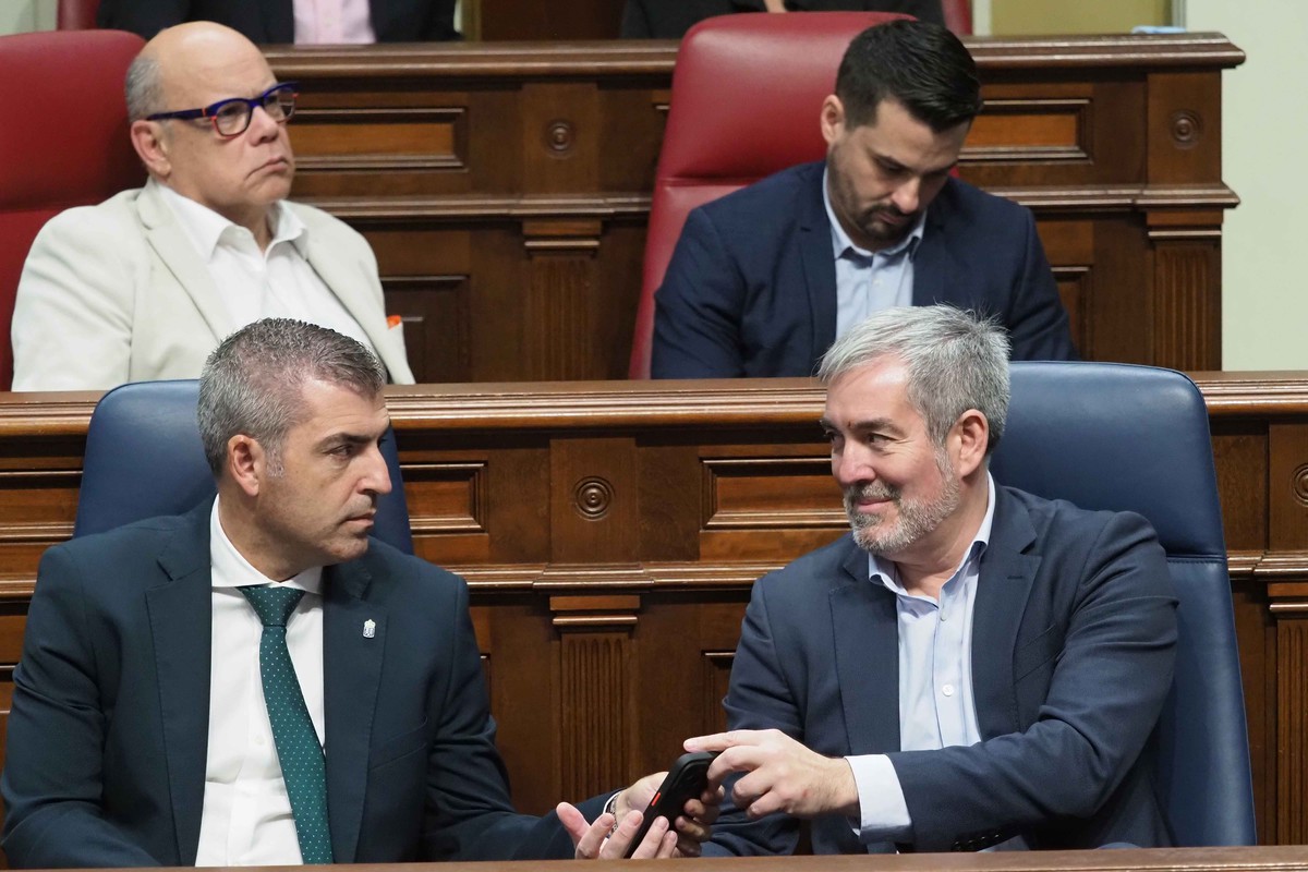 Clavijo muestra la pantalla de su móvil a Domínguez durante el pleno de ayer. Sergio Méndez