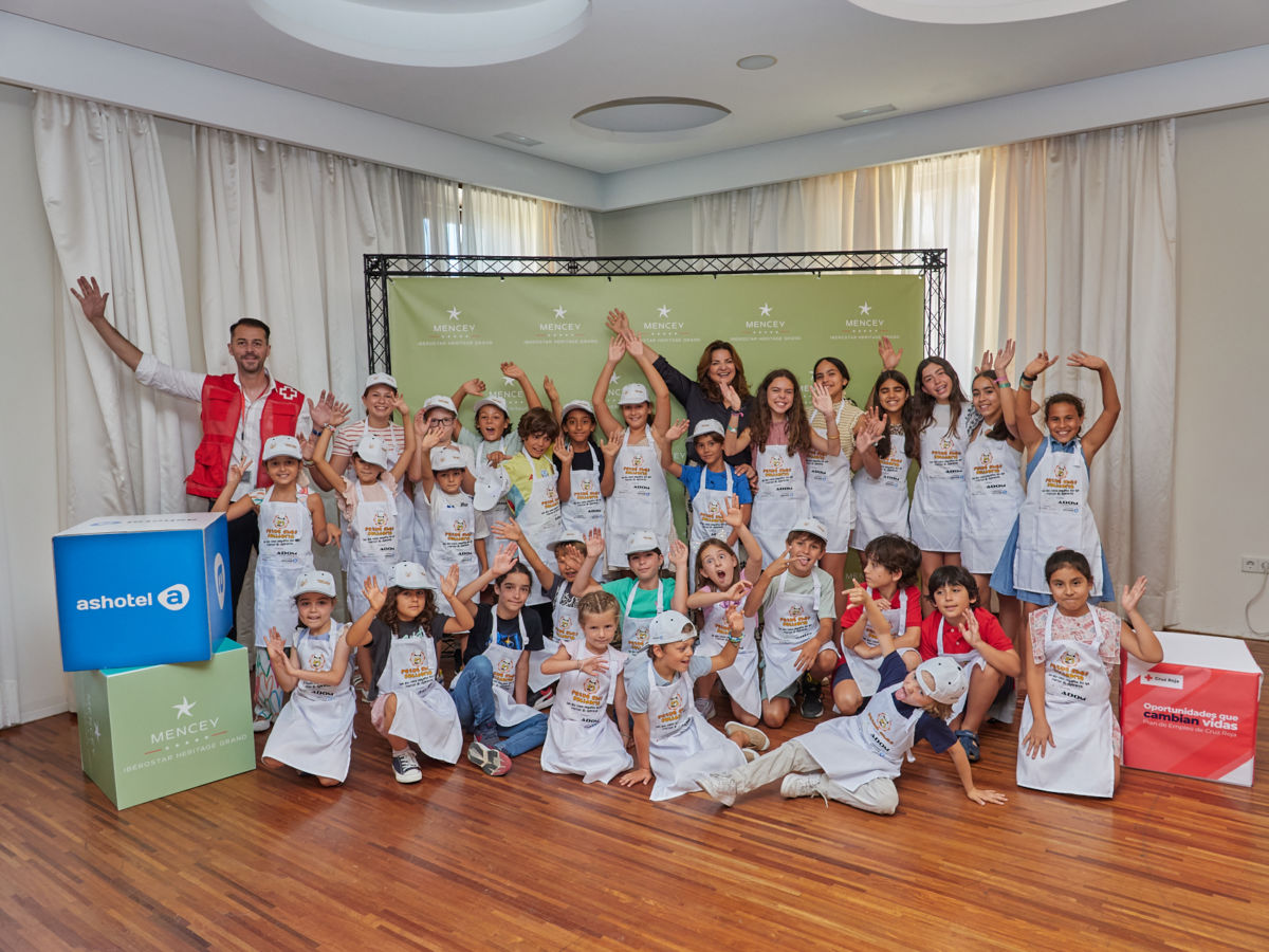 Unos 60 niños y adultos cocinan en equipo una merienda saludable