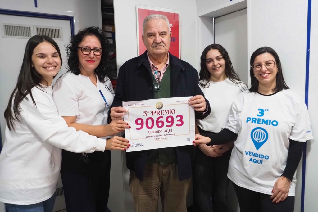 José María González de Chaves celebra con sus empleadas y su familia en la puerta de su local, en la calle de San Agustín, donde un cartel confirma la venta de diez décimos del número afortunado. Sergio Méndez