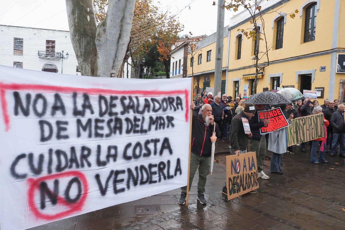 La lluvia no impidió que más de cien personas se concentraran ayer frente al Consistorio para mostrar su rechazo a la desaladora. Sergio Méndez