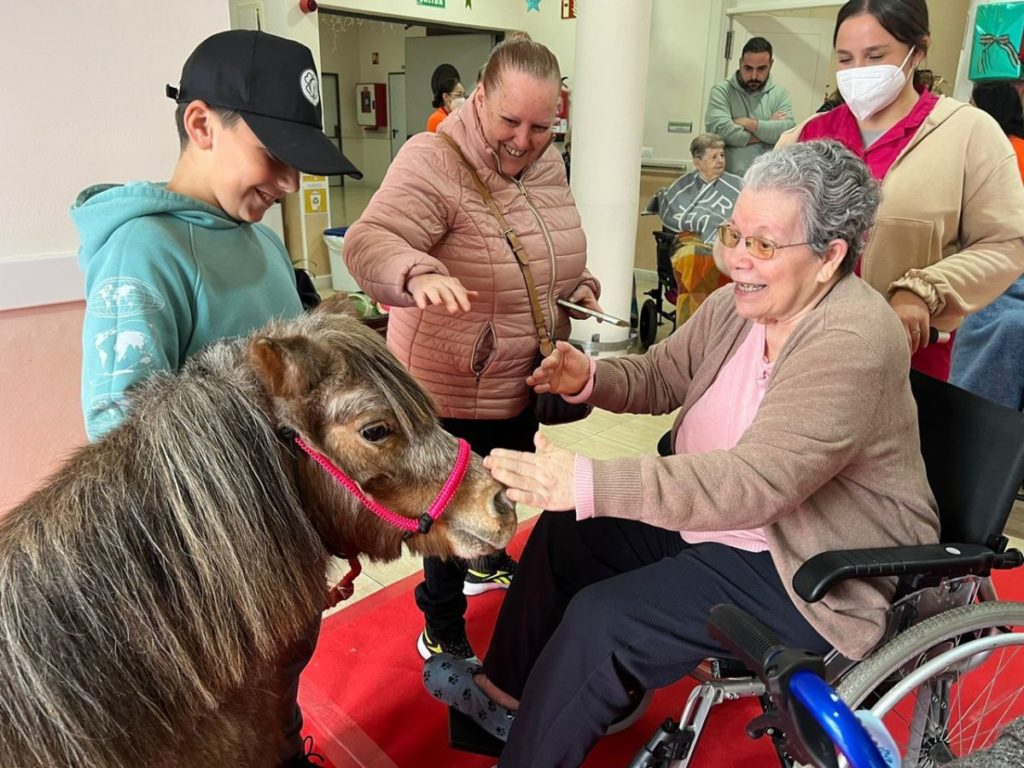 Una usuaria no puede ocultar su alegría al interactuar con uno de los ponis que visitaron el centro, gestionado por la Fundación Gerón.