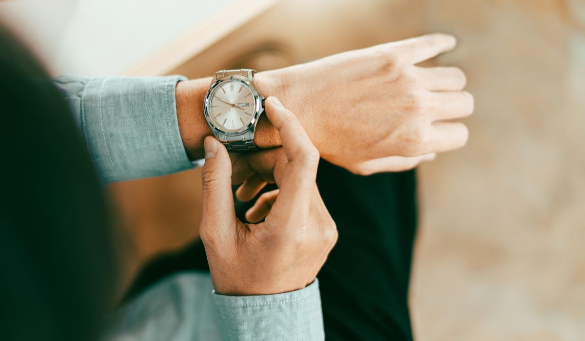 Una persona ajusta la hora en su reloj