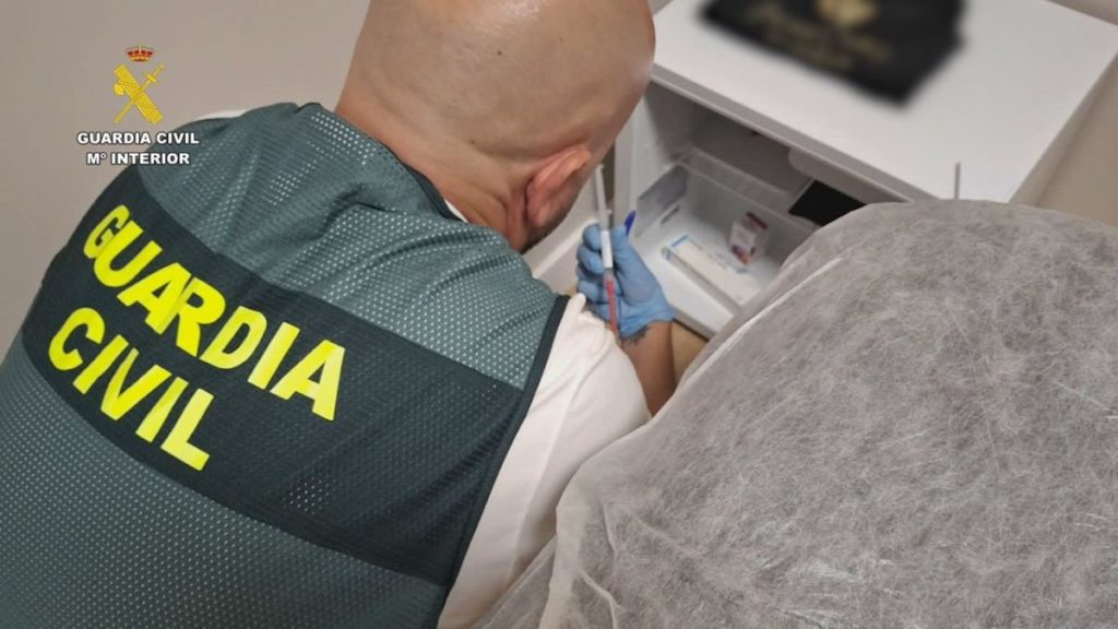 Agentes de la Guardia Civil junto a cajas de medicamentos, viales de toxina botulínica y ácido hialurónico intervenidos en una operación contra la estética clandestina