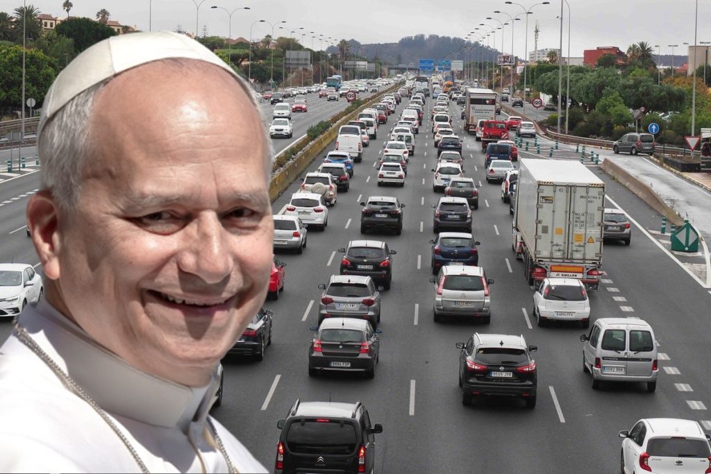 Un fotomontaje en primer plano muestra al Papa León XIV sonriente, con su solideo, superpuesto a una vista aérea de una autopista TF-5 en Tenerife totalmente congestionada con tráfico denso. Los vehículos están atrapados en largas colas que se extienden hacia el fondo bajo un cielo nublado, con edificios y árboles a los lados