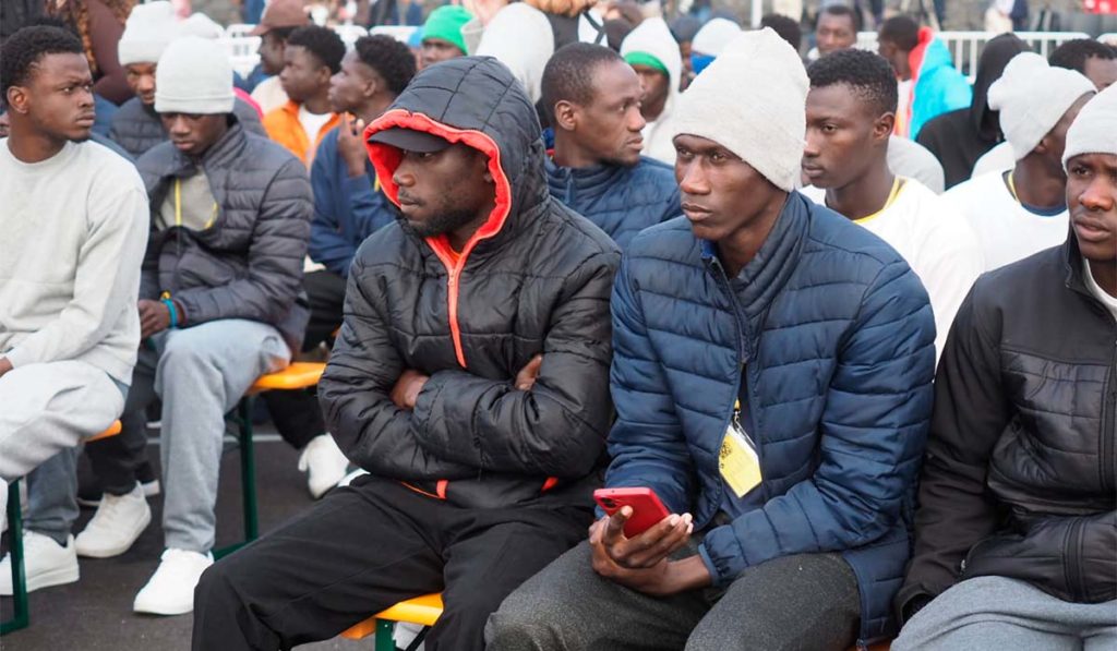 Decenas de migrantes esperan en Las Raíces a León XIV que es “muy buena gente”