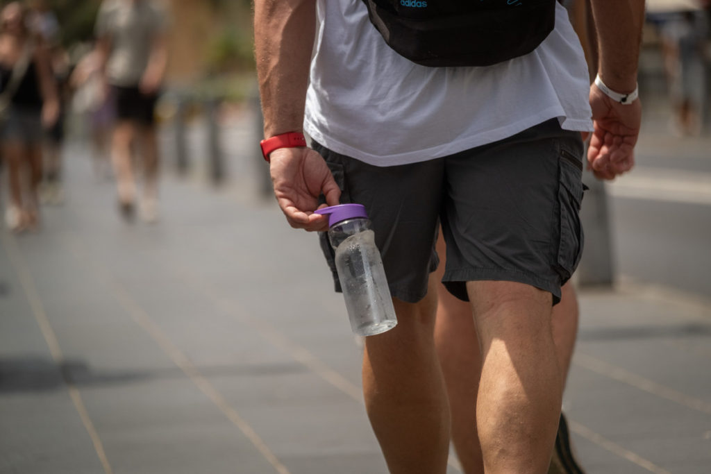 Un hombre camina con una botella de agua durante una jornada de altas temperaturas en Santa Cruz de Tenerife. | Sergio Méndez