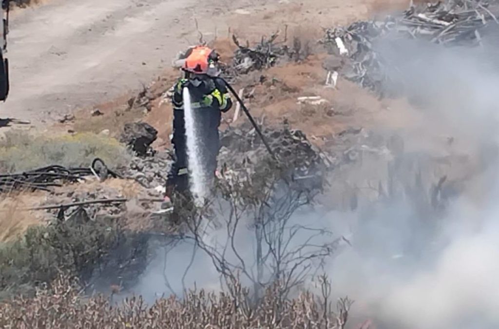 Un bombero apaga el fuego que se se originó en la trasera de la subida a la calle Guanches Virgen de Candelaria. | Ayuntamiento de Candelaria