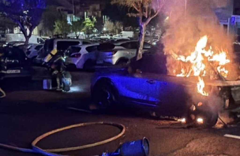 Un vehículo arde en la calle Juan Rumeu García, en Santa Cruz de Tenerife, durante la noche del martes, mientras los servicios de emergencia intervienen en la zona. | DA