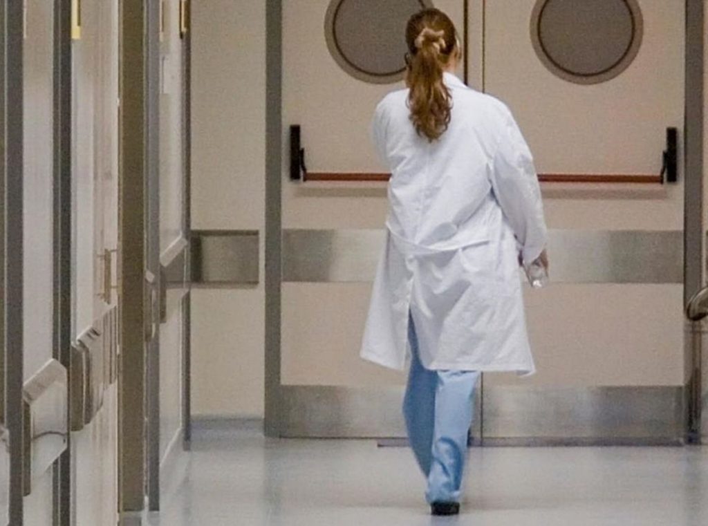 Una auxiliar de enfermería camina por los pasillos de un hospital