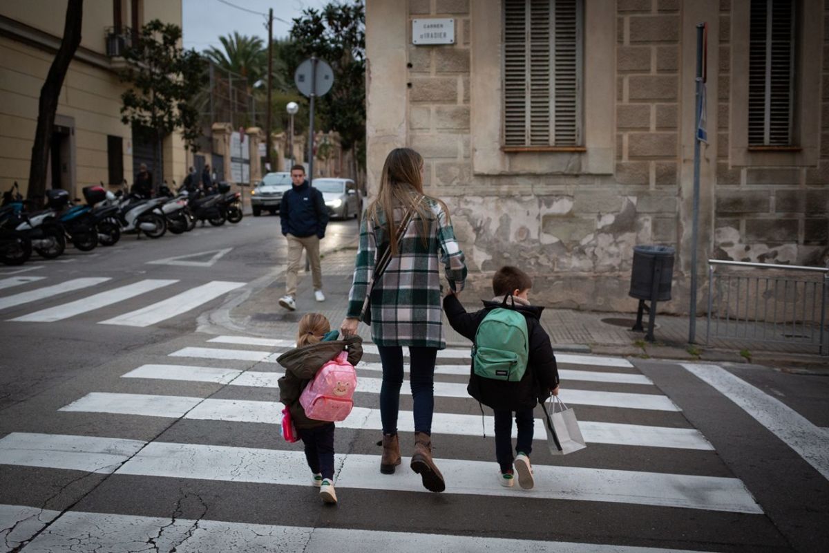 Una madre lleva a sus hijos al colegio. | EP