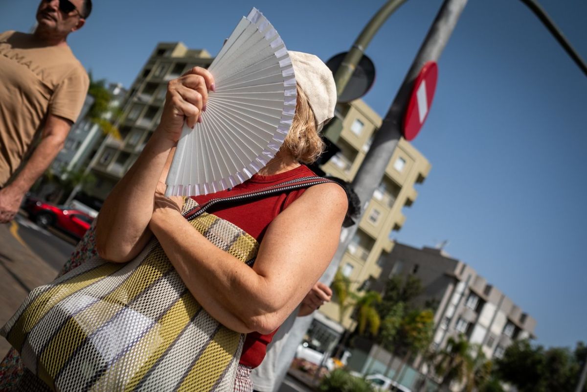Una santacrucera alivia el bochorno con un abanico en la capital, en imagen captada a primeros del pasado julio. | Fran Pallero